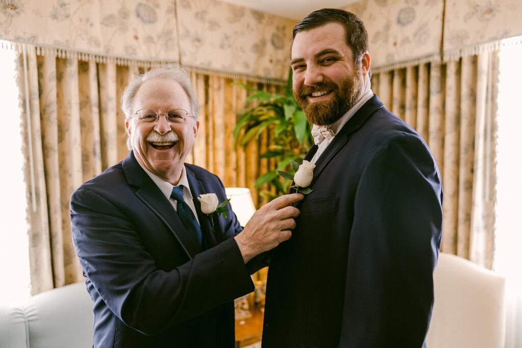 Dad putting boutonniere on Groom on his wedding day