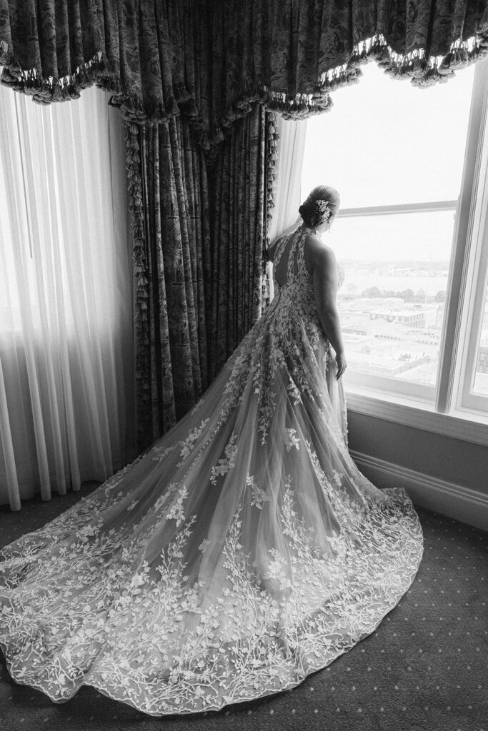 Bride looking out window at Hotel Monteleone on wedding day