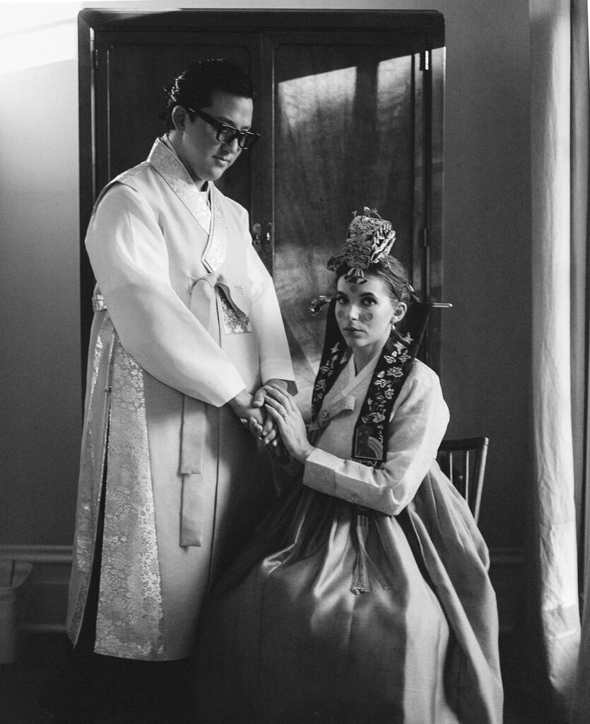 Bride and Groom dressed for Korean Ceremony photographed with traditional film wedding photography in black and white..