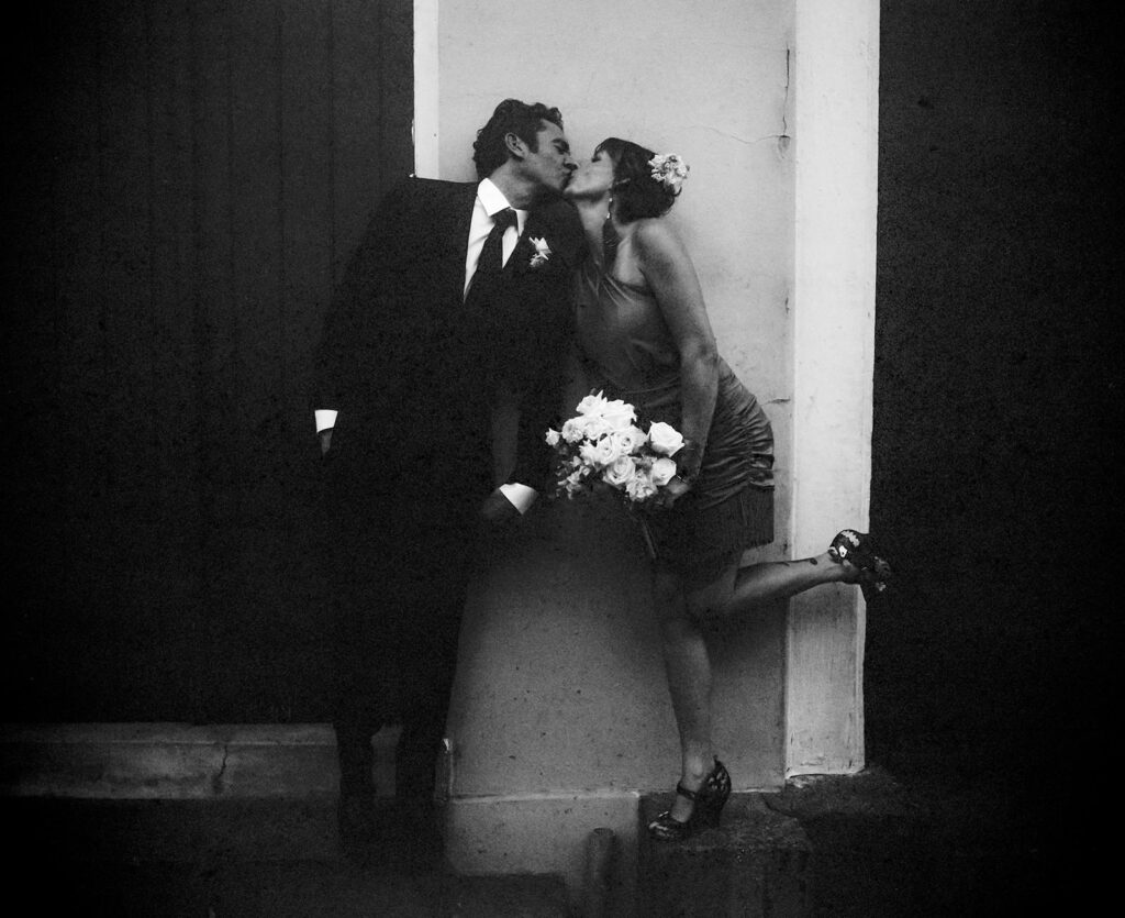 Bride and Groom kissing on their wedding day with black and white film photography.