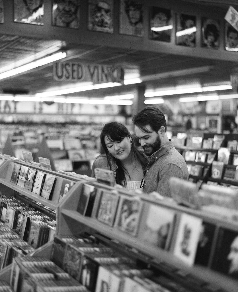 Couple record shopping at Peaches Records on Magazine Street in New Orleans with black and white film photography for engagement session.