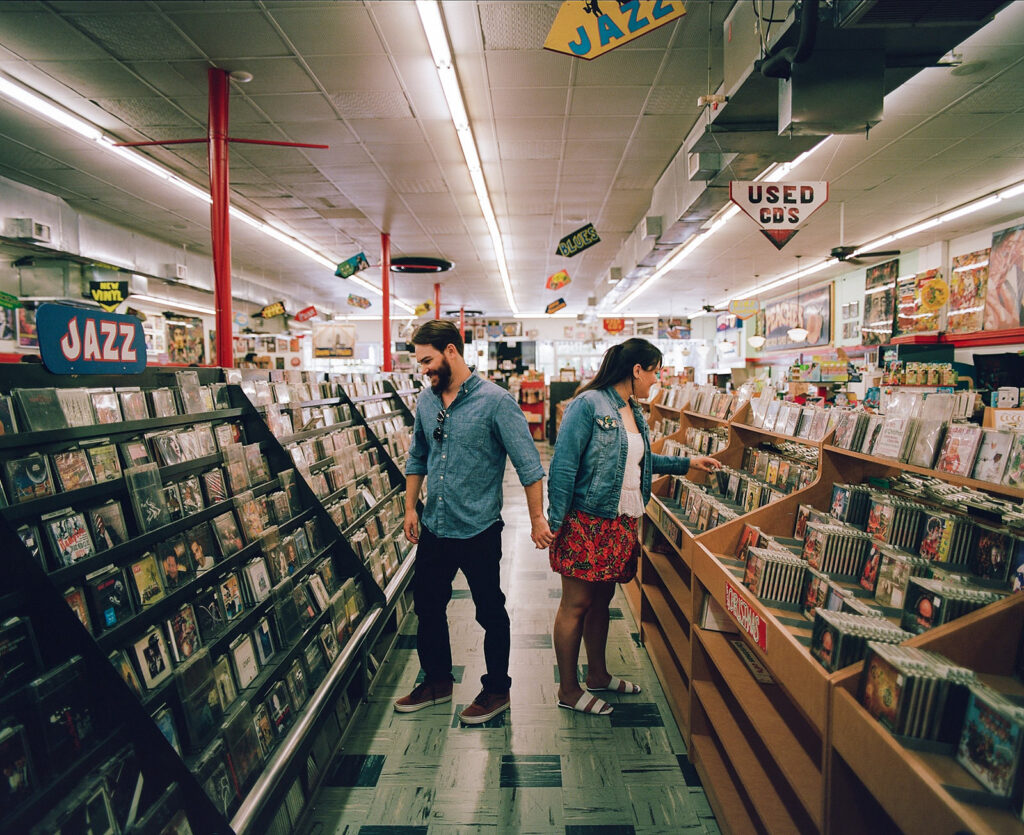 Couple record shopping at Peaches Records on Magazine Street in New Orleans with color film photography for engagement session.